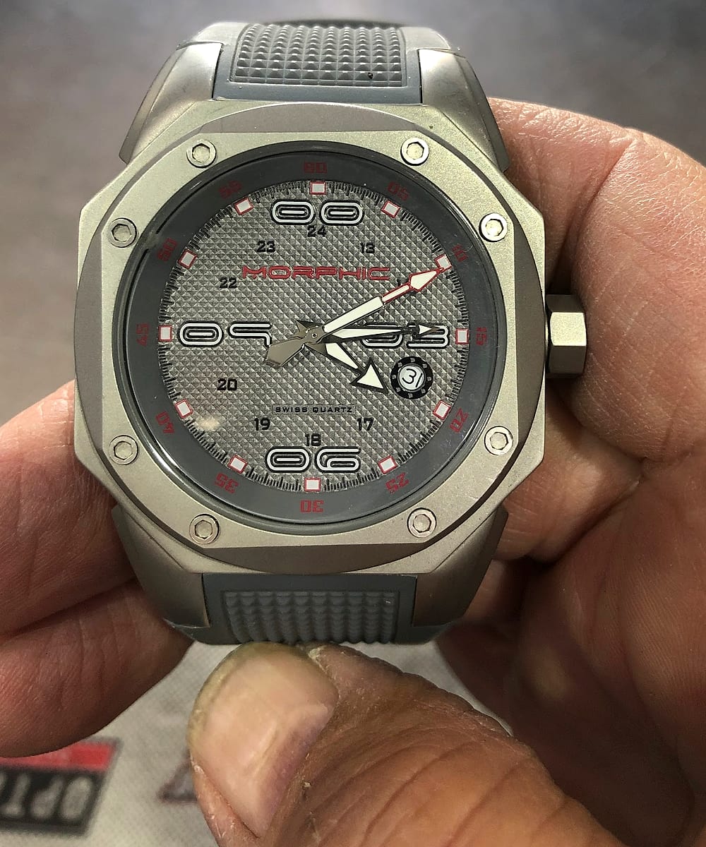 A watch being inspected by hand at the counter